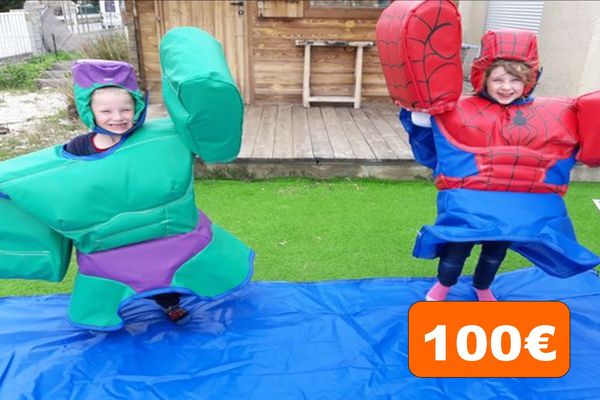 deux enfants qui lèvent les bras. Le garçon habillé en sumo Hulk et la fille habillé en sumos Spider man