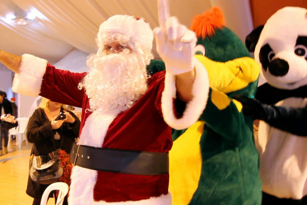 le pere noel qui fait la chenille avec une mascotte dinosaure et une mascotte panda