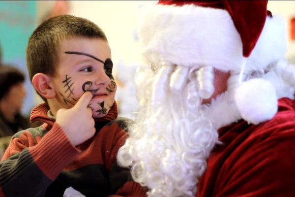 un enfant maquillé en pirate qui regarde le pere noel