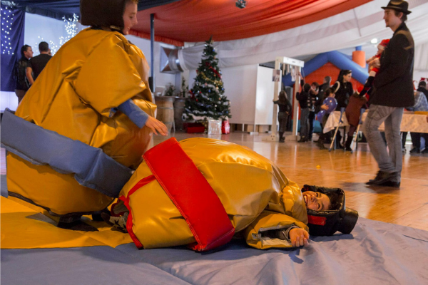 des enfants habillés en sumos qui jouent, un allongés sur le tatami et l'autre debout