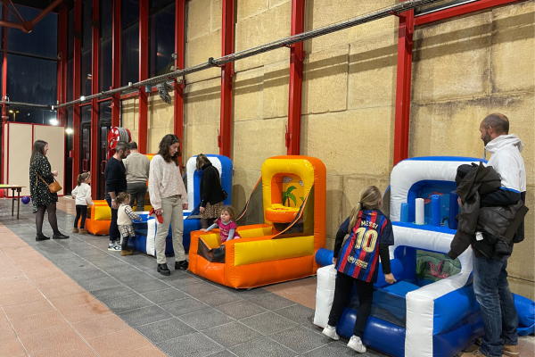 Kermesse gonflable avec des enfants qui jouent aux jeux de lancés accompagnés de leurs parents